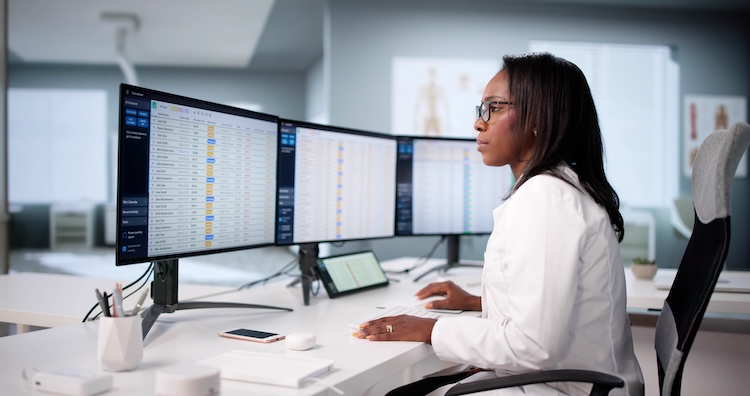 A billing specialist analyzing revenue cycle and claims data on a computer